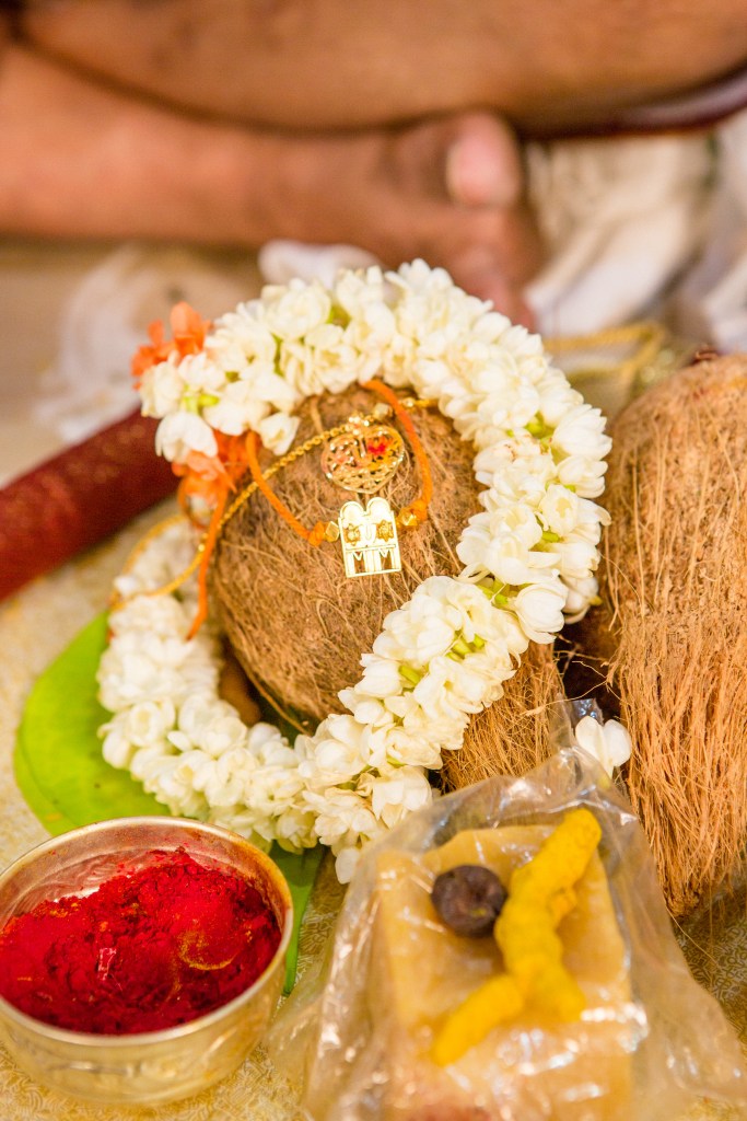Coconut decorated with flower garland and magalyam.